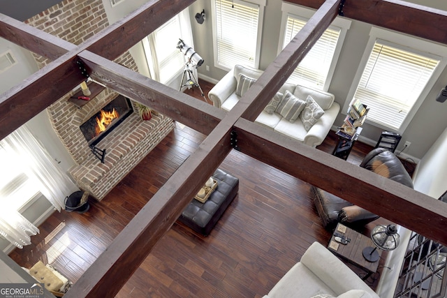 living room with dark wood-type flooring and a brick fireplace