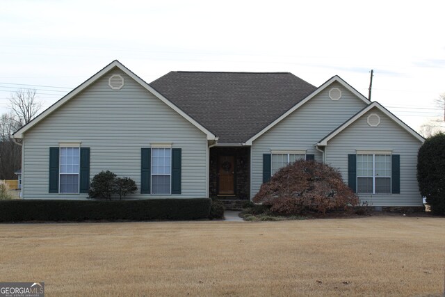 ranch-style home featuring a front lawn