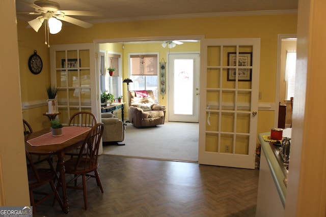 dining space featuring ornamental molding, ceiling fan, dark parquet floors, and french doors