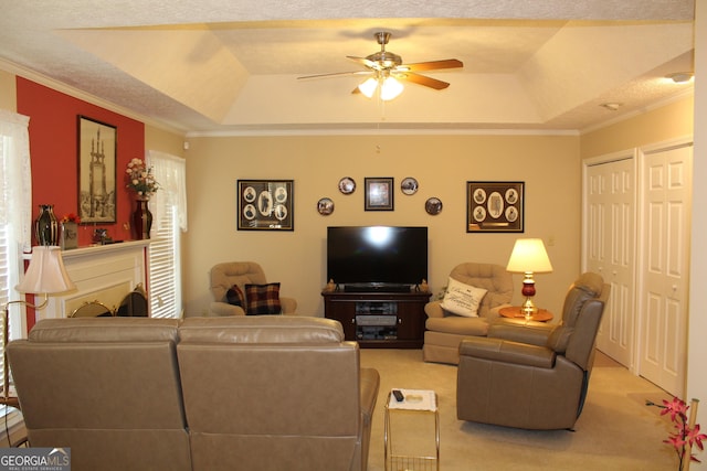 carpeted living room featuring crown molding, ceiling fan, and a raised ceiling