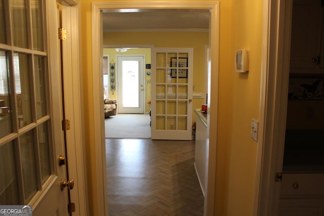 corridor featuring french doors, ornamental molding, and parquet floors