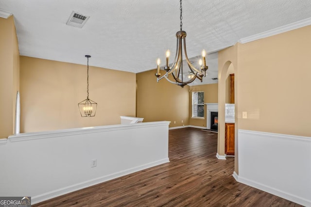 unfurnished dining area with lofted ceiling, dark hardwood / wood-style flooring, a chandelier, and a textured ceiling