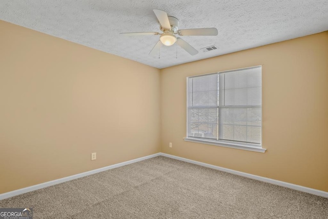 carpeted spare room with a textured ceiling and ceiling fan