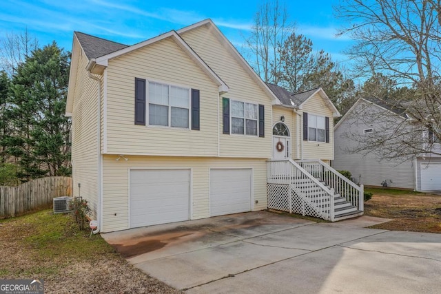 raised ranch featuring cooling unit and a garage