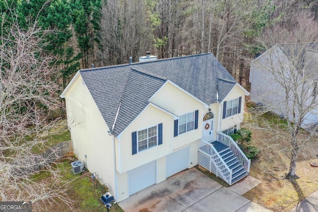 view of front of home with a garage and central AC