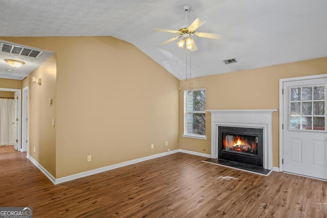 unfurnished living room featuring ceiling fan, wood-type flooring, and vaulted ceiling