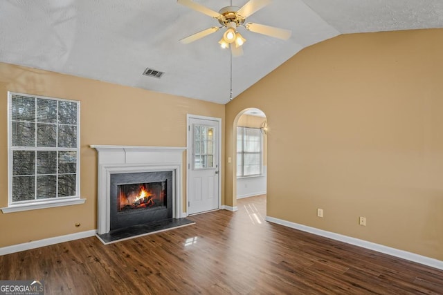 unfurnished living room featuring lofted ceiling, hardwood / wood-style flooring, a high end fireplace, and ceiling fan