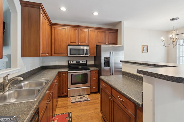 kitchen with sink, light hardwood / wood-style flooring, appliances with stainless steel finishes, decorative light fixtures, and a chandelier