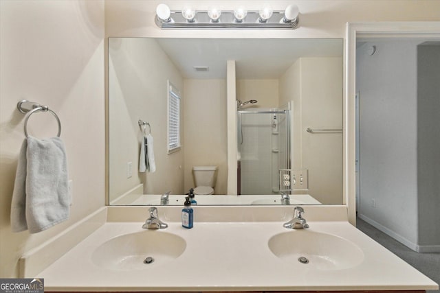 bathroom featuring vanity, a shower with shower door, and toilet