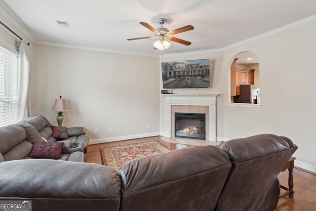 living room featuring hardwood / wood-style flooring, crown molding, and ceiling fan