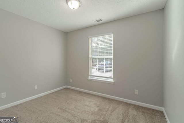 empty room with a textured ceiling and carpet