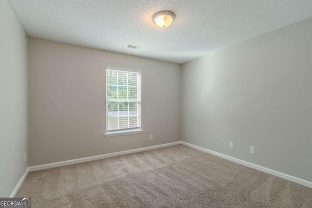 carpeted spare room with a textured ceiling