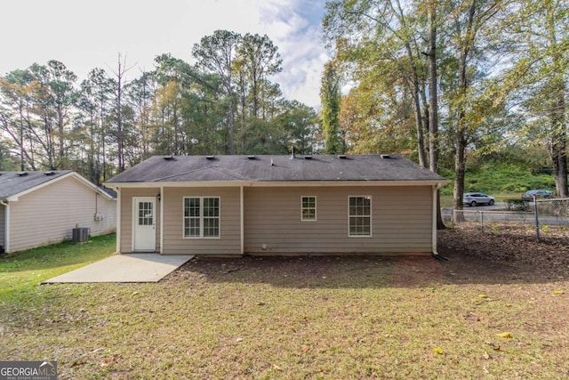 rear view of property with a yard, a patio, and central air condition unit