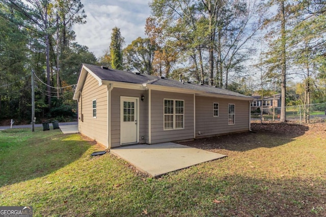 rear view of property with a yard and a patio area