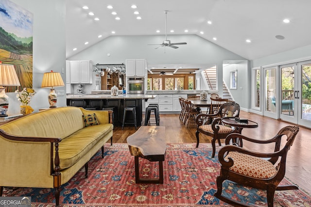 living room featuring hardwood / wood-style flooring, ceiling fan, high vaulted ceiling, and french doors