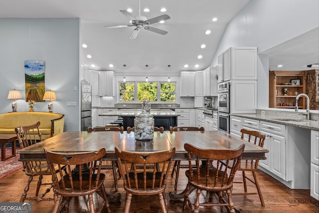 dining area featuring sink, high vaulted ceiling, dark hardwood / wood-style floors, and ceiling fan