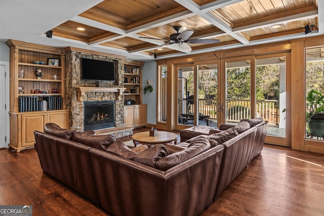 living room featuring beam ceiling, dark hardwood / wood-style floors, coffered ceiling, a fireplace, and wooden ceiling