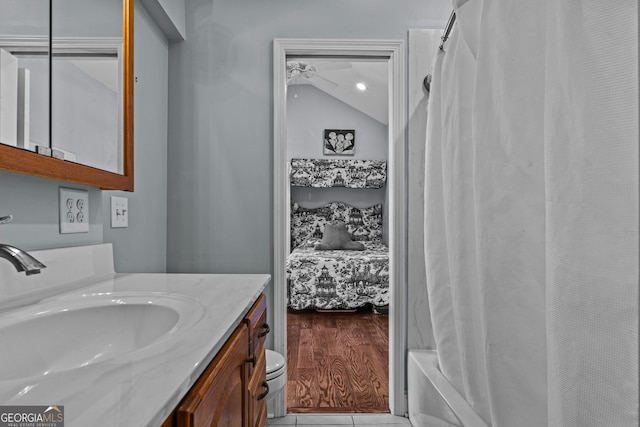 bathroom featuring vanity, vaulted ceiling, and shower / bath combination with curtain