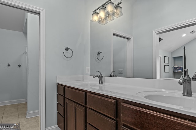 bathroom featuring tile patterned floors, vanity, and vaulted ceiling