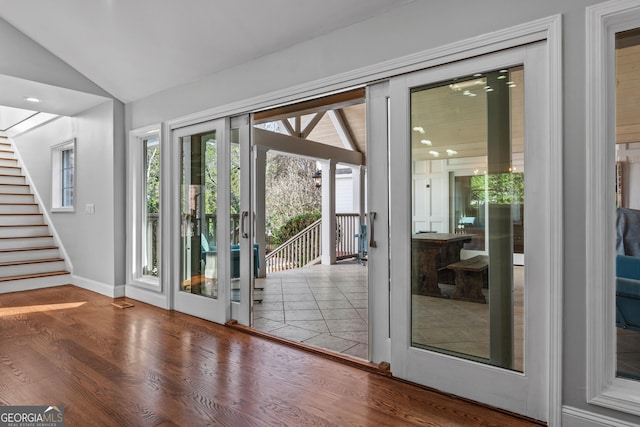 doorway to outside featuring hardwood / wood-style floors and vaulted ceiling