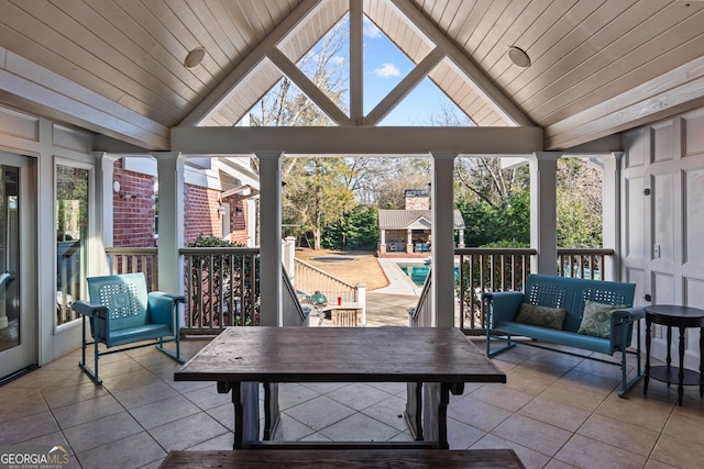 sunroom with lofted ceiling, wood ceiling, and ornate columns