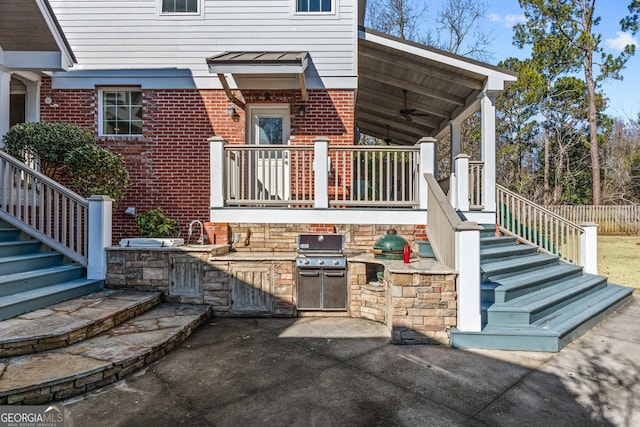 rear view of house with an outdoor kitchen, ceiling fan, and a patio area