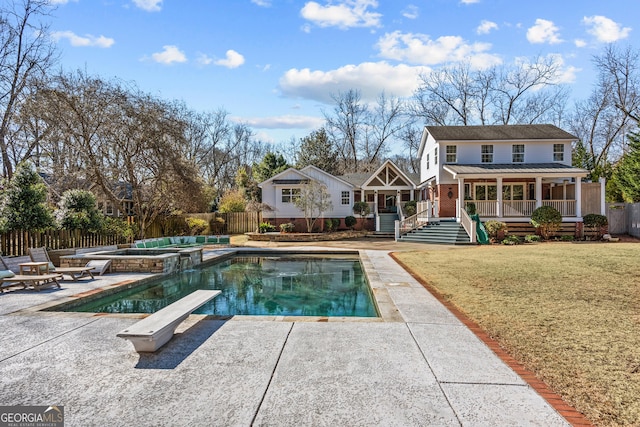 view of swimming pool featuring a yard, a patio area, a diving board, and a jacuzzi