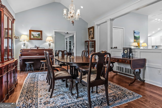 dining room with dark wood-type flooring, high vaulted ceiling, decorative columns, and a notable chandelier