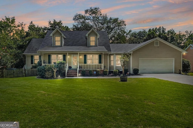 new england style home featuring a garage, a yard, and covered porch