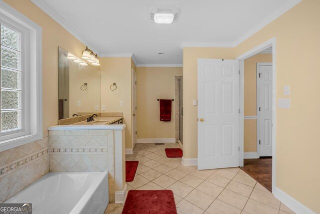 bathroom featuring vanity, a bath, crown molding, and tile patterned floors