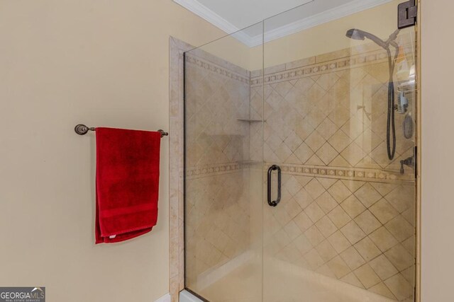 bathroom featuring a shower with door and ornamental molding