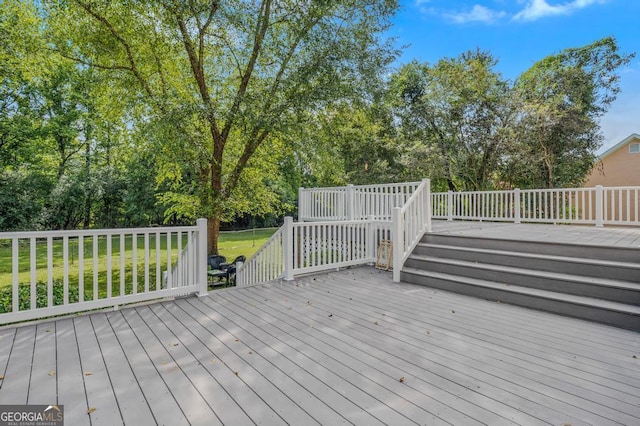 wooden deck featuring a lawn