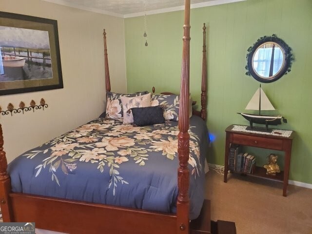 bedroom featuring ornamental molding and carpet