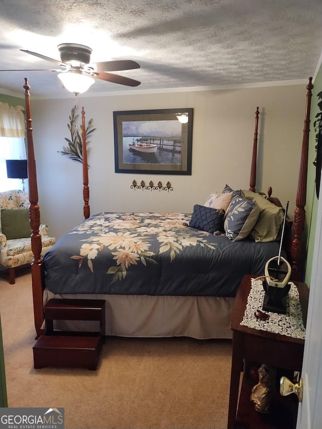 carpeted bedroom featuring ceiling fan, ornamental molding, and a textured ceiling