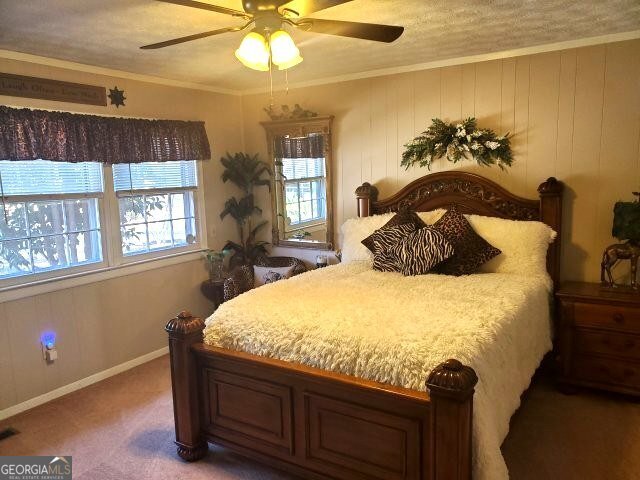 bedroom featuring ornamental molding, carpet floors, and ceiling fan