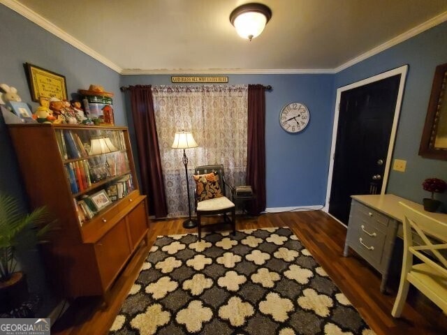 sitting room with dark wood-type flooring and ornamental molding