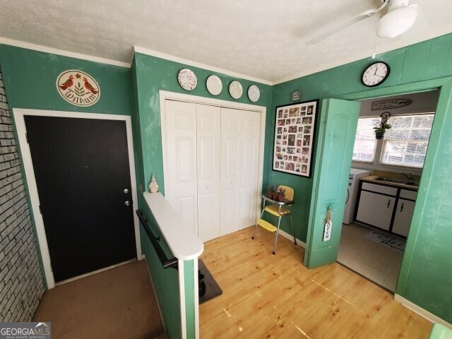 foyer with ceiling fan, ornamental molding, sink, and hardwood / wood-style floors