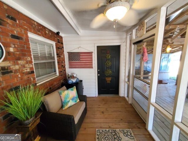 interior space with ceiling fan and a porch