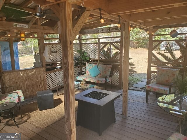 deck featuring a gazebo, ceiling fan, and an outdoor fire pit