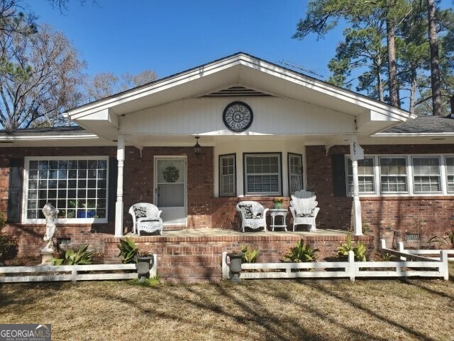 view of front of property featuring covered porch and a front lawn