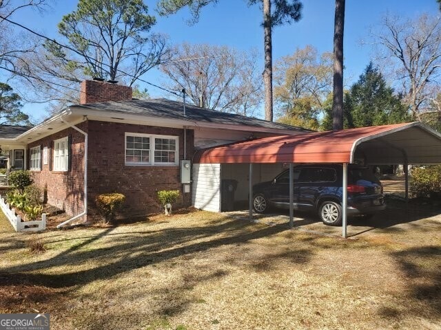 view of property exterior featuring a carport and a yard