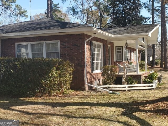 view of property exterior featuring a yard and covered porch