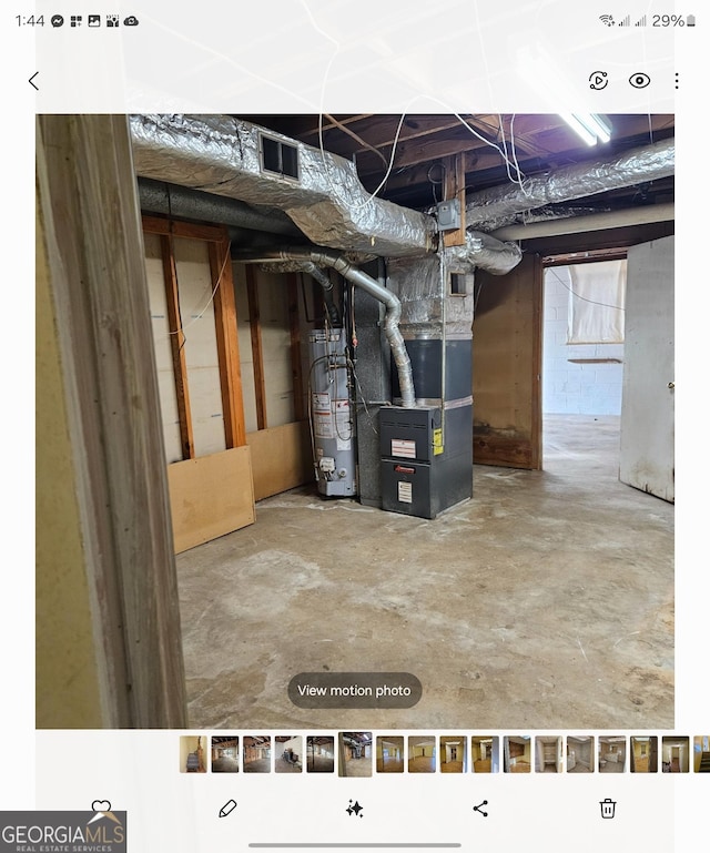 basement featuring heating unit and water heater