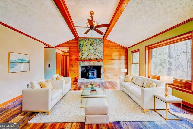 living room with hardwood / wood-style floors, lofted ceiling with beams, ceiling fan, crown molding, and a textured ceiling