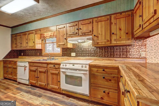 kitchen with butcher block countertops, sink, a textured ceiling, white appliances, and hardwood / wood-style floors