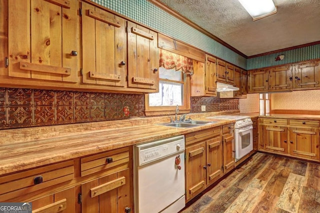 kitchen featuring sink, white appliances, dark hardwood / wood-style floors, ornamental molding, and a textured ceiling