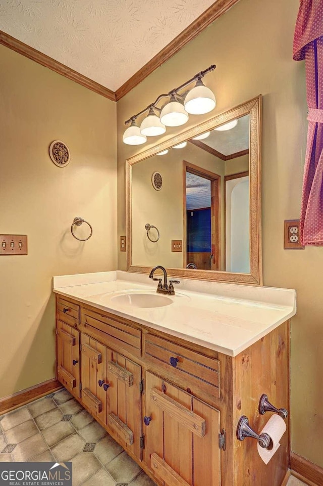 bathroom with crown molding, vanity, and a textured ceiling