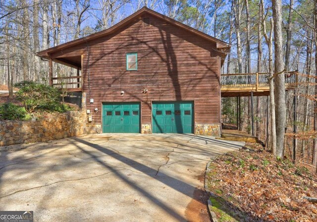 view of property exterior with a garage and a wooden deck