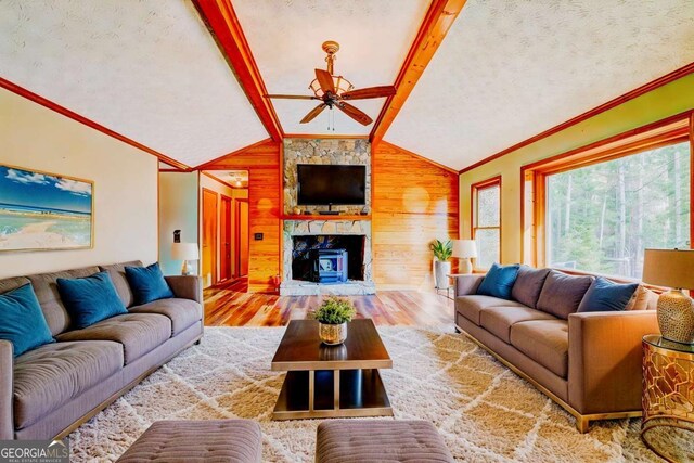 living room featuring hardwood / wood-style flooring, crown molding, vaulted ceiling with beams, and ceiling fan