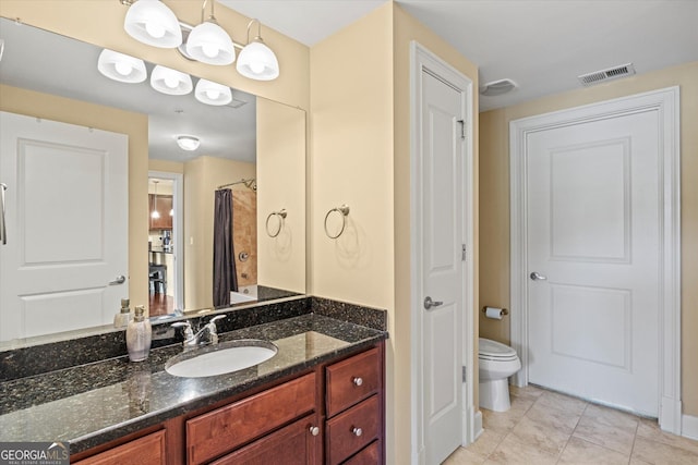 bathroom featuring vanity, tile patterned flooring, toilet, and walk in shower